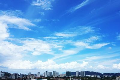 View of cityscape against cloudy sky