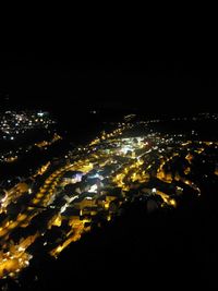 Aerial view of illuminated cityscape against sky at night