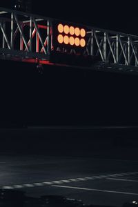 Illuminated bridge over river against sky at night