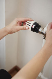 Woman using radiator thermostat