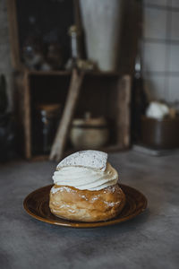 Bun with whipped cream on plate