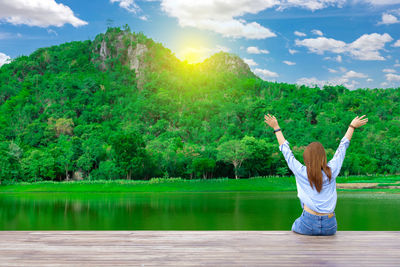 Woman standing by lake against sky
