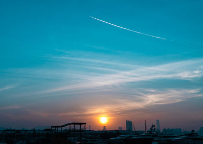 Scenic view of vapor trails in sky during sunset