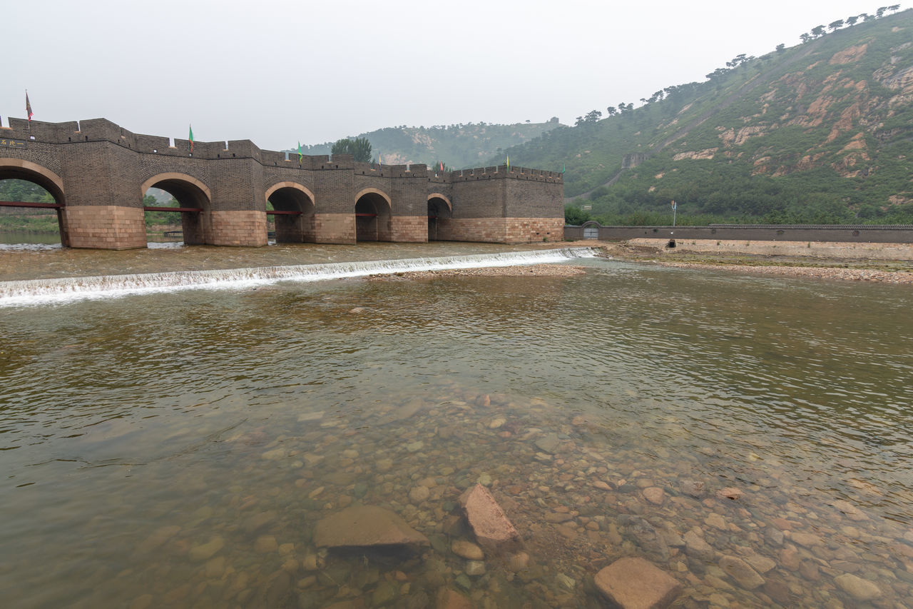 VIEW OF ARCH BRIDGE OVER RIVER AGAINST SKY