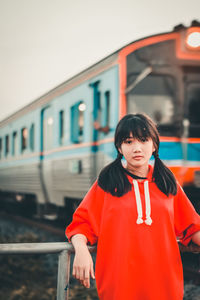 Portrait of girl standing against train