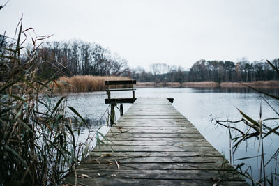 Pier over lake against sky during winter