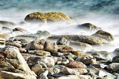 Scenic view of rocks in sea against sky