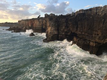 Scenic view of rocks in sea against sky