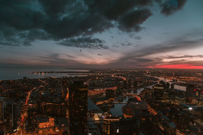 Aerial view of illuminated cityscape against sky at night