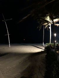 Illuminated street light on beach at night