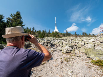 Photography with pensioner using analog camera during trip on jested mountain with ufo restaurant