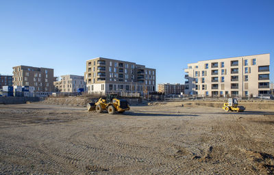 People at construction site against clear sky