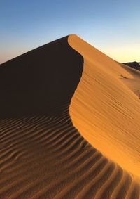 Sand dune in desert against clear sky