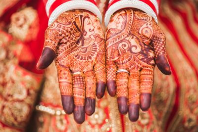High angle view of henna tattoo on bride hands
