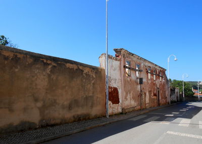 Street by building against blue sky