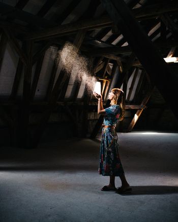 FULL LENGTH OF WOMAN STANDING ON CEILING IN BUILDING