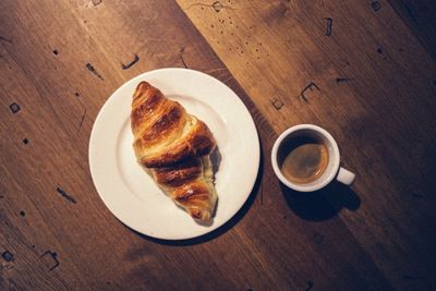 High angle view of coffee cup on wooden table