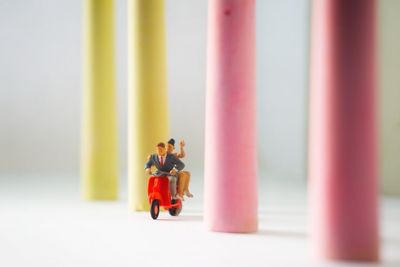 Close-up of figurines riding motor scooter by chalks on table