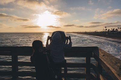 Mother and son in ferry looking at beach sunset