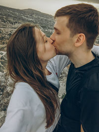 Portrait of young couple kissing outdoors