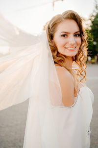 Portrait of smiling bride standing outdoors