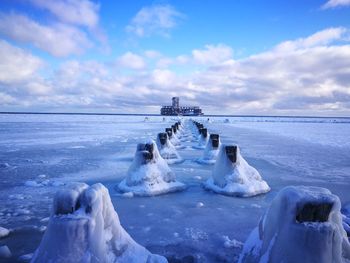 Frozen sea against sky during winter