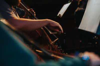 Midsection of man playing cello