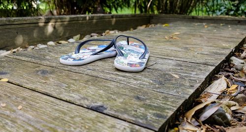 Close-up of shoes on wooden bench