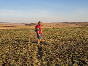 Full length of man walking on field against sky