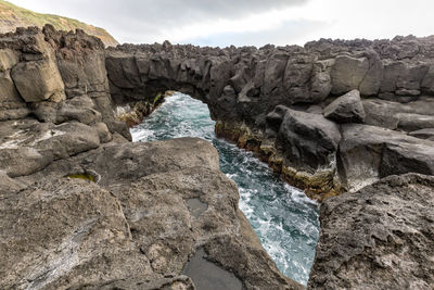 Rock formations by sea against sky