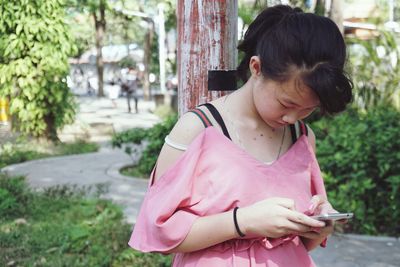 Girl looking away while standing outdoors