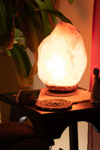 Close-up of illuminated lamp on table