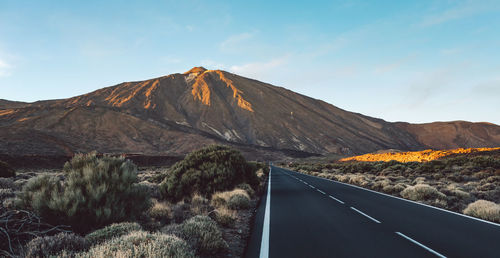 Road by mountain against sky