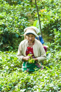 Full length of woman standing by flowering plants