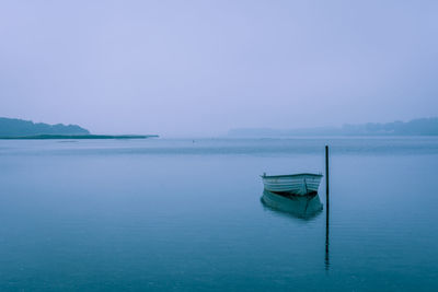 Scenic view of boat on lake against clear sky