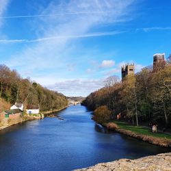 River amidst trees against blue sky