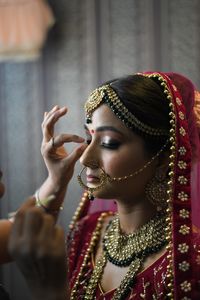 Beautician applying make-up to bride