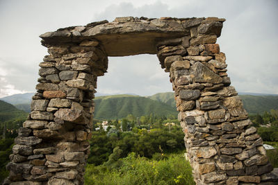 Stone wall against cloudy sky