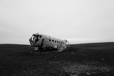 Abandoned airplane on field against sky