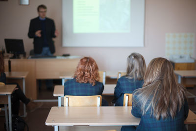 Rear view of students sitting in classroom