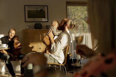 Fathers with their babies resting in living room