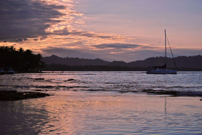 Sailboats on sea against sky during sunset