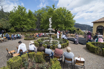 People sitting at park against sky