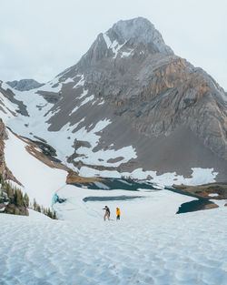 A couple hiking a snowy mountain in the middle of winter