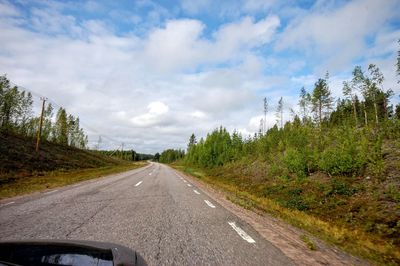 Road amidst trees against sky