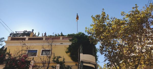 Low angle view of trees and houses against sky