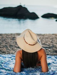 Rear view of woman with hat on beach