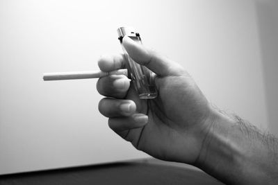 Close-up of hand holding cigarette