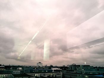 Buildings in city against cloudy sky