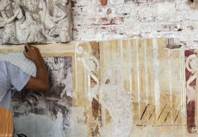 Midsection of woman carving on wall